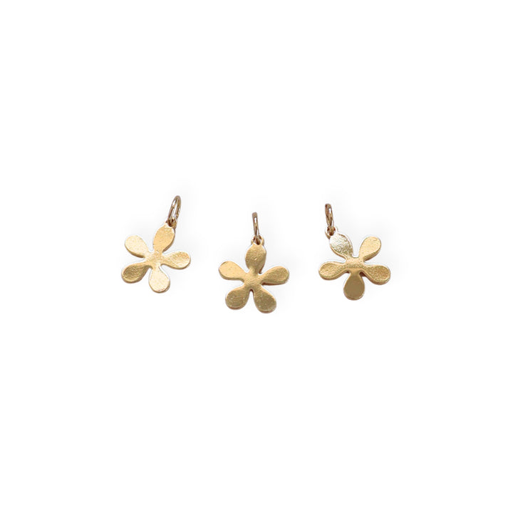Detalles de dije dorado en forma de flor elaborado en chapa de oro