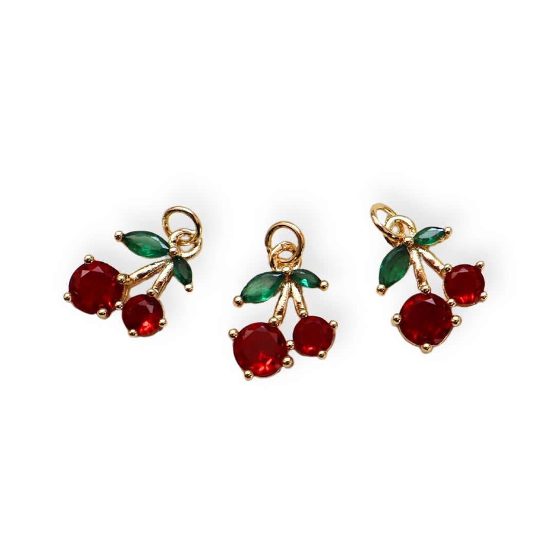 Detalles de dije en forma de cereza dorada con zirconia brillante
