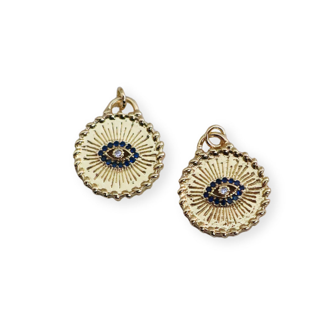 Detalles de dije circular dorado con ojo turco y zirconias en chapa de oro