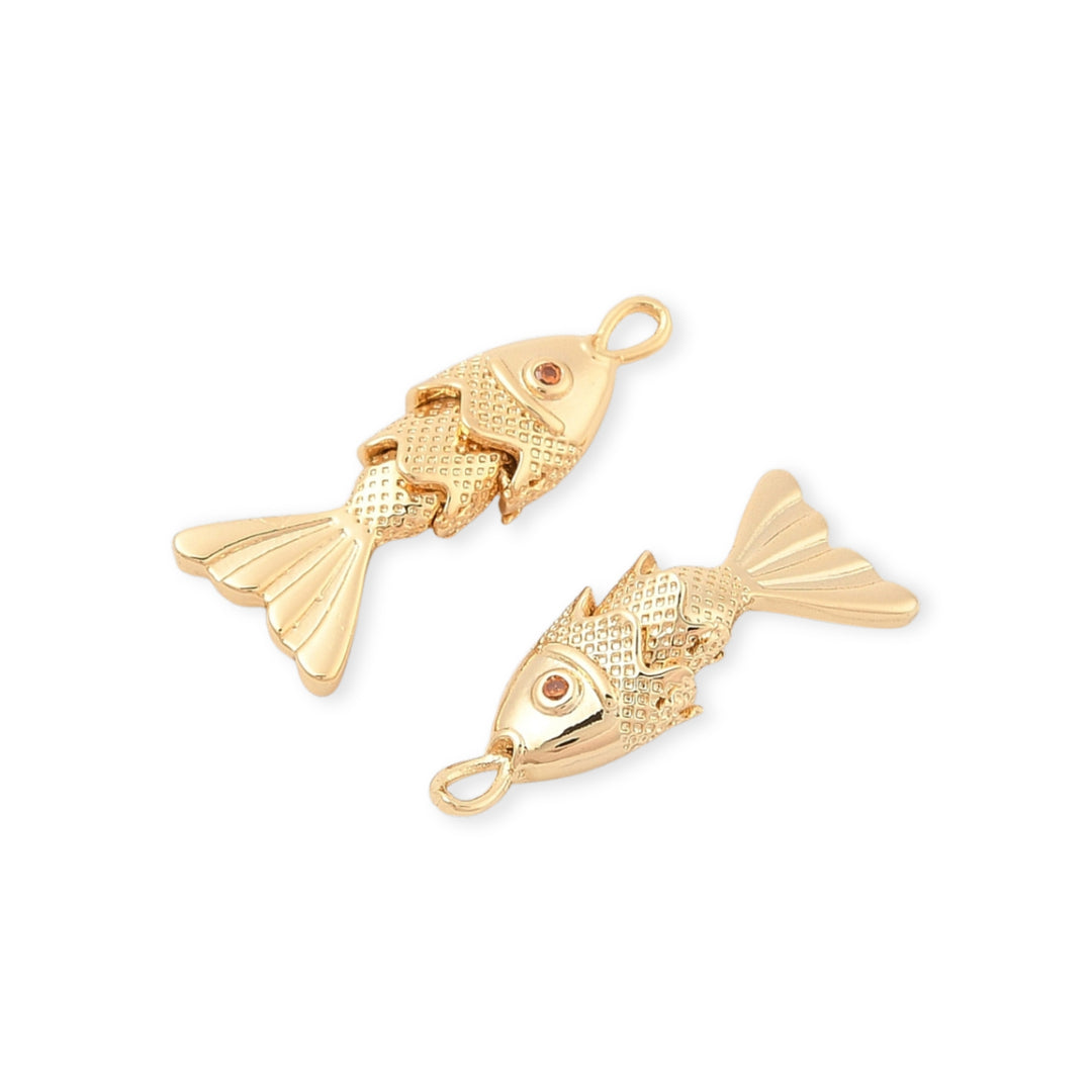 Detalles de Dije dorado en forma de pez con zirconia y aleta móvil sobre fondo blanco