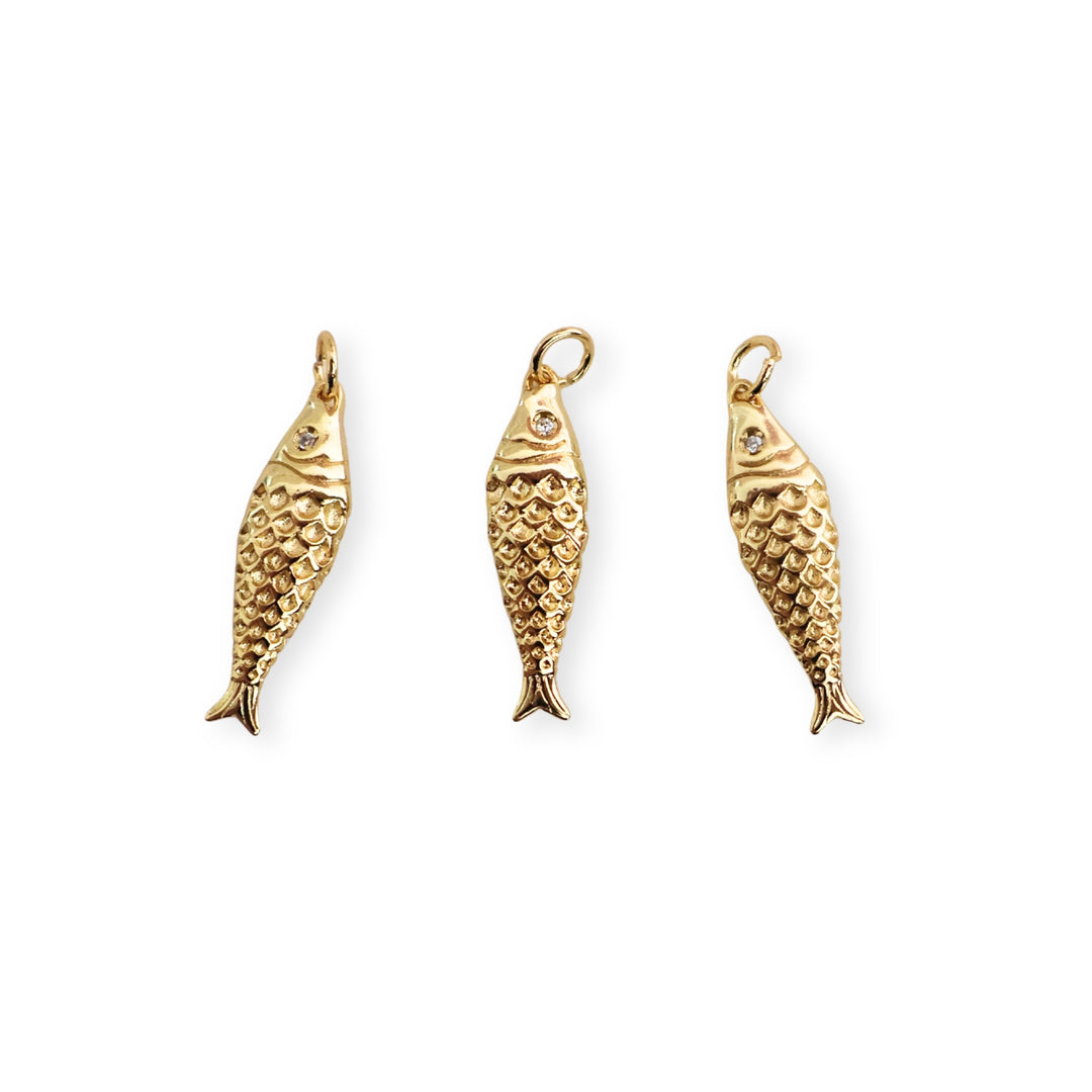 Detalle de dijes de pescado dorado con zirconia en el ojo sobre fondo blanco