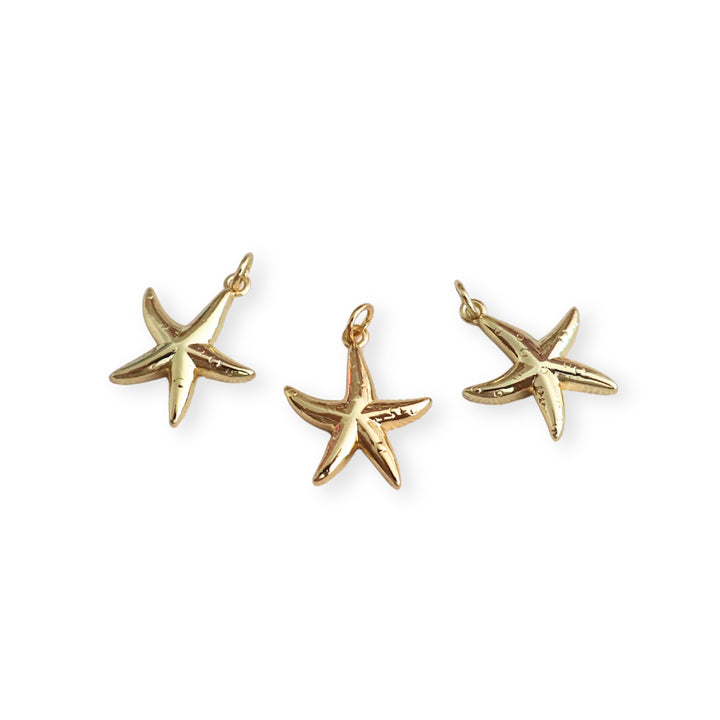 Detalle de dijes dorados en forma de estrella de mar elaborado en chapa de oro
