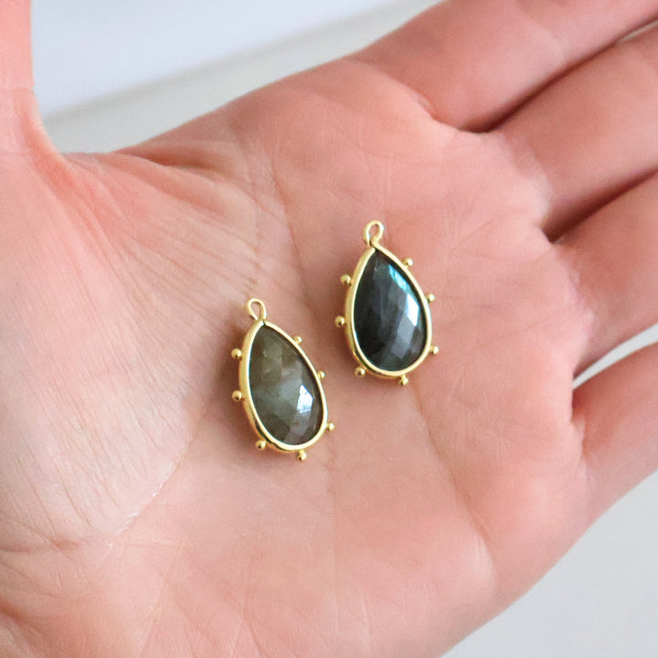 Dije de gota de labradorita con base de chapa de oro en mano