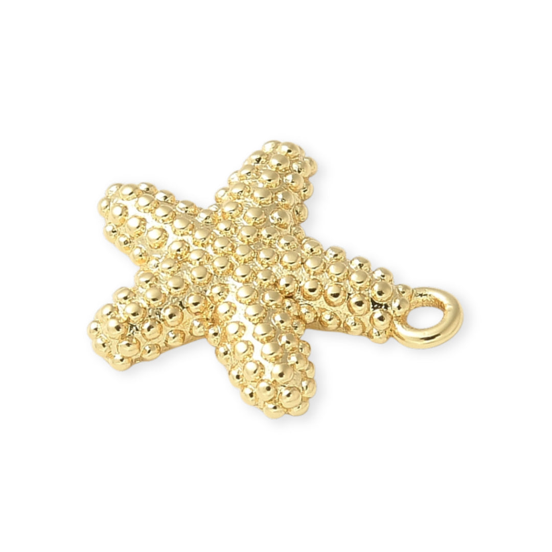Detalles de Dije de estrella de mar en chapa de oro con textura de puntos sobre fondo blanco