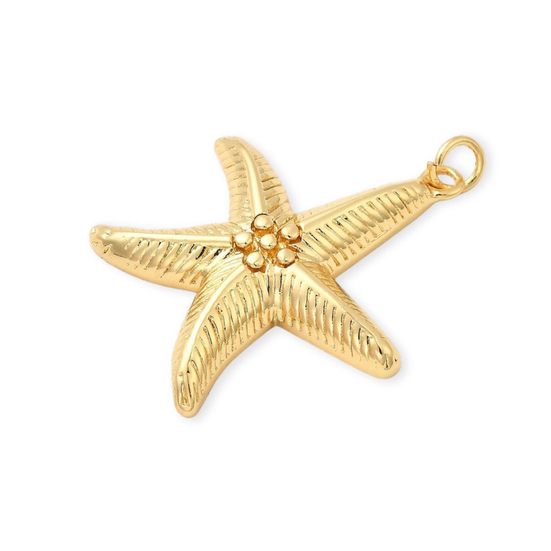 Detalle de dijes en forma de estrella de mar dorada con detalle de bolitas en el centro