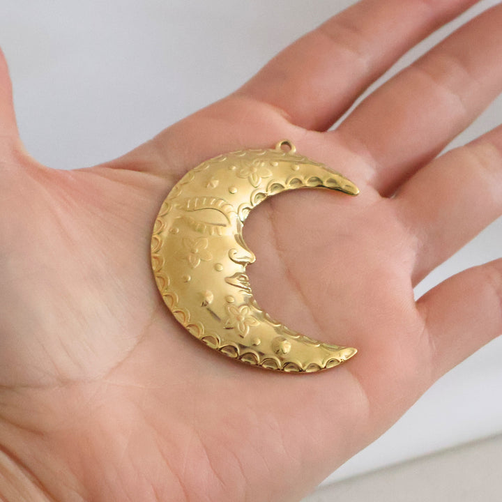 Dije de luna de acero inoxidable grande en mano
