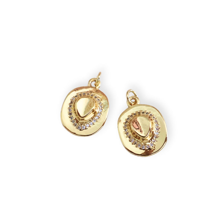 Detalle de dije en forma de sombrero de chapa de oro con zirconia