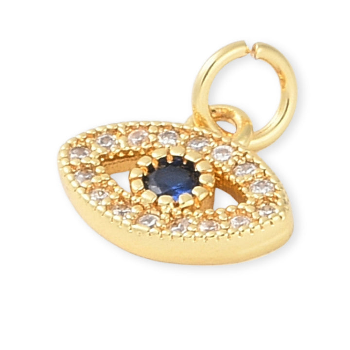 Detalles de Dije dorado en forma de ojo con zirconias y centro azul oscuro