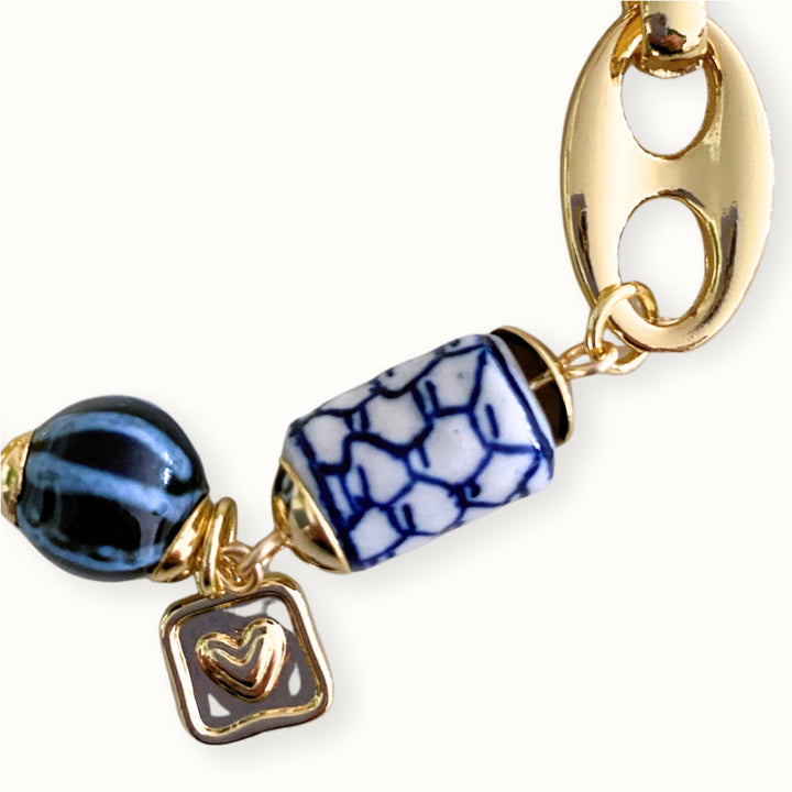 Detalle de Brazalete de cadena de chapa de oro con dije cuadrado de corazón