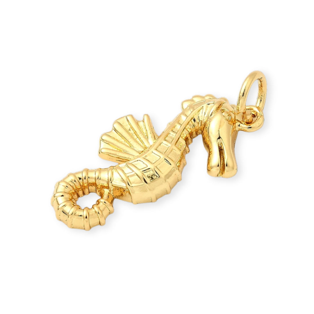 Detalles de Dije dorado en forma de caballito de mar sobre fondo blanco