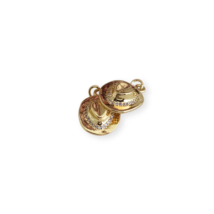 Detalle de dije en forma de sombrero de chapa de oro con zirconia