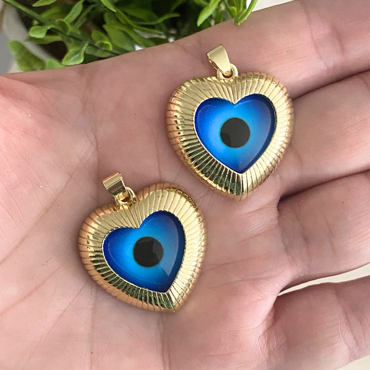 Dije corazón de chapa de oro con ojo turco encapsulado en mano