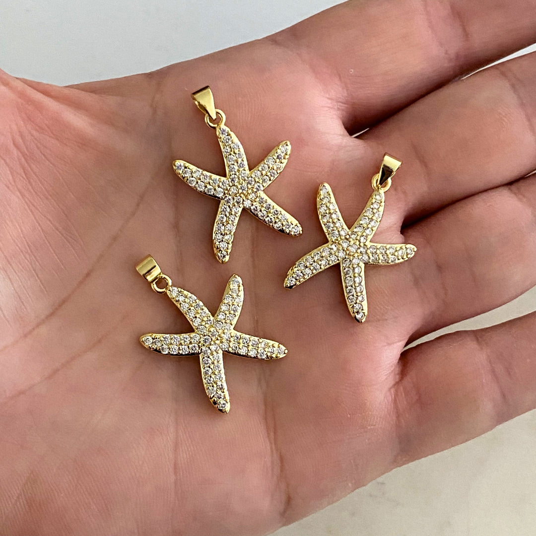Detalles de Dije de estrella de mar en chapa de oro con zirconias sobre fondo blanco