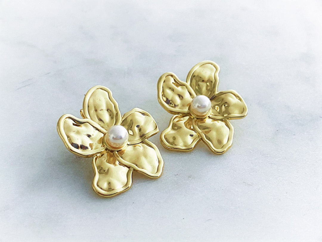 Detalle de Aretes Camelia – diseño floral dorado con perla central