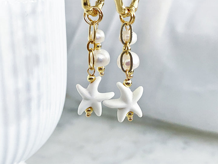 Detalle de Arracadas de chapa de oro Almendra – perlitas y estrella de mar blanca

