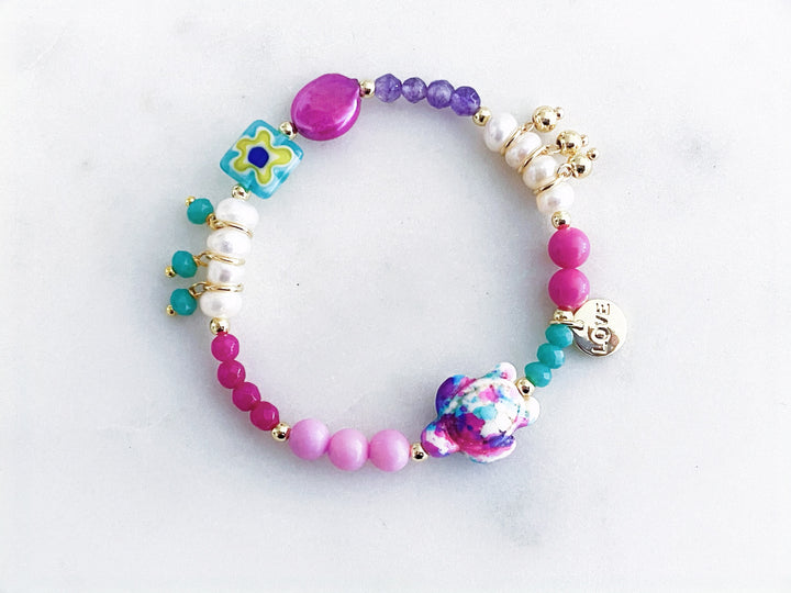 Pulsera multicolor de piedras naturales, perlas y cristales con dije de tortuga y placa “love”, vista completa.