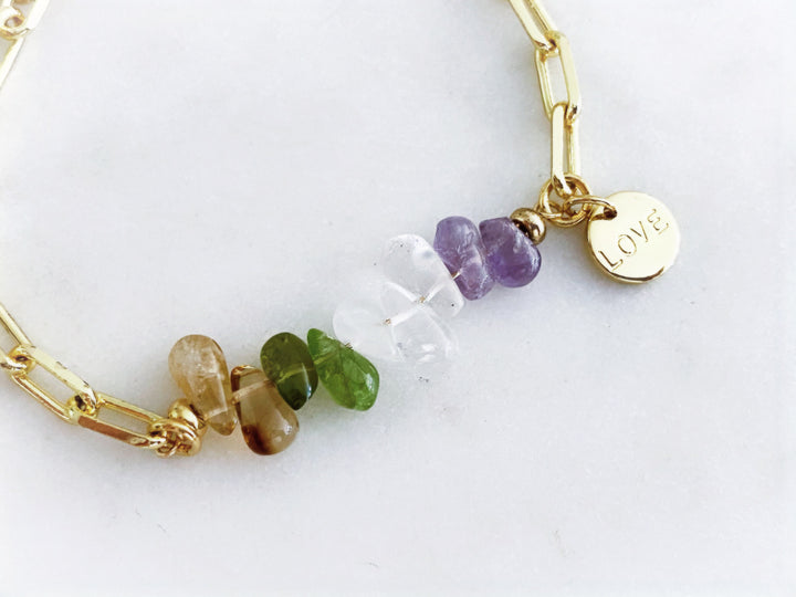 Detalle de la piedra de fluorita y la placa “Love” bañada en oro en la pulsera Cléa.
