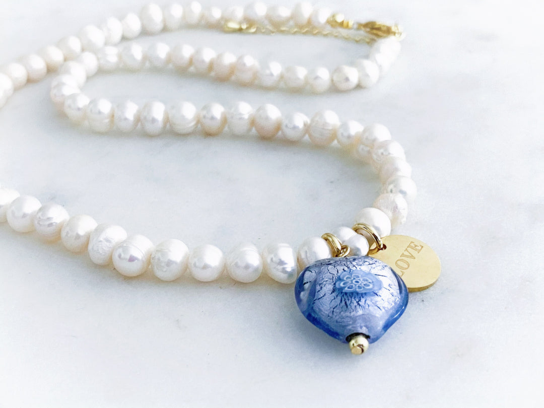 Detalle del corazón de cristal Murano y la placa dorada 'Love' del collar Élia