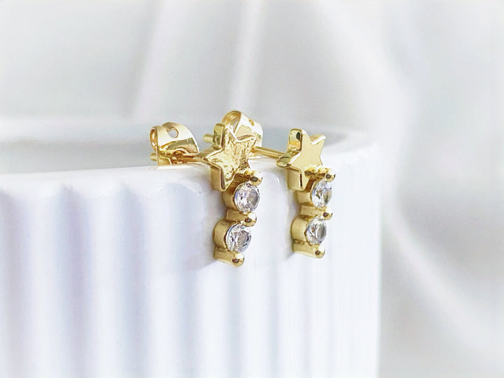 Detalle de los aretes Estelar con estrella y dijes colgantes en zirconia