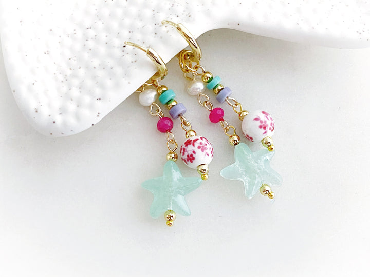 Detalle de arracadas con piedras pastel y dije de estrella acrílica