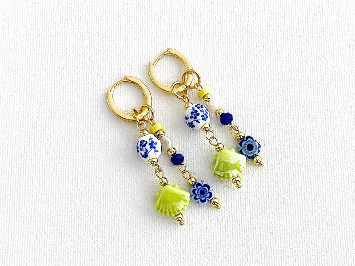 Detalle de arracadas de chapa de oro Lima – concha verde y flores cerámicas blancas

